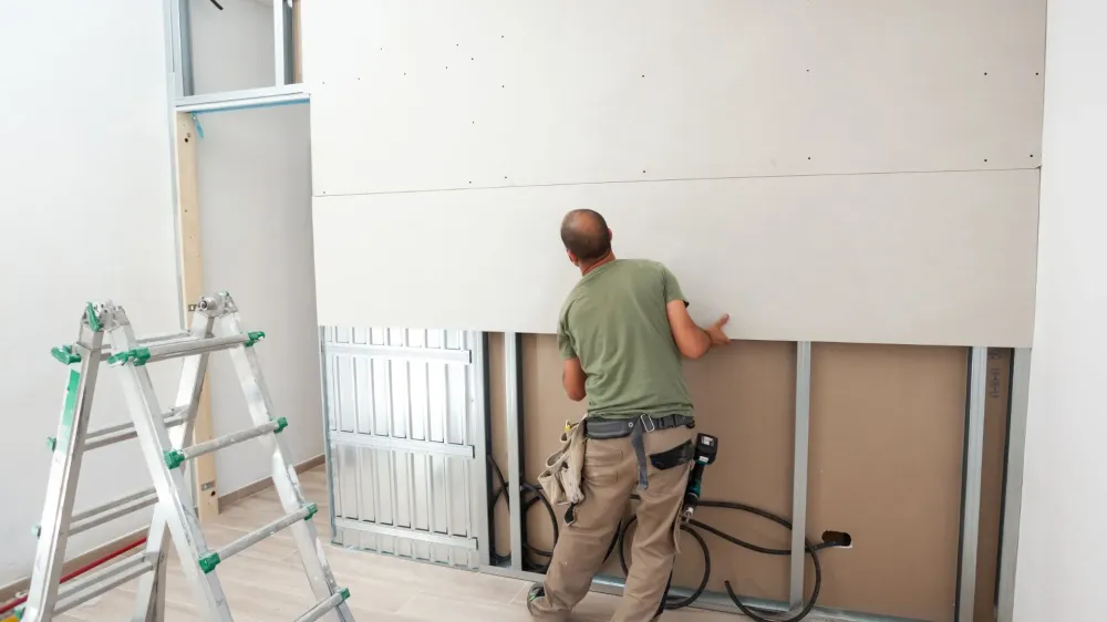 ouvrier posant des plaques de plâtrewebp